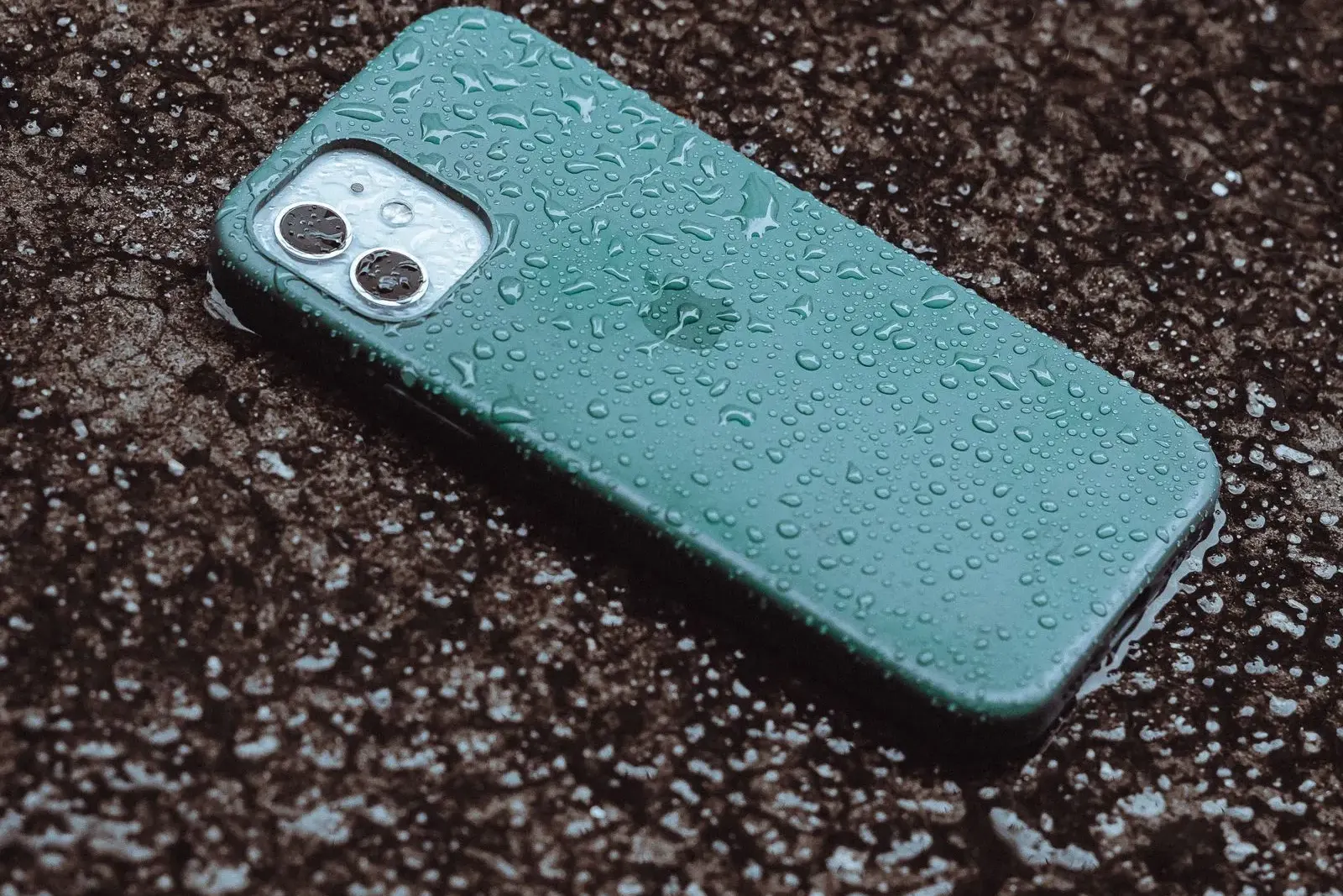 A rain soaked iPhone lying on wet pavement