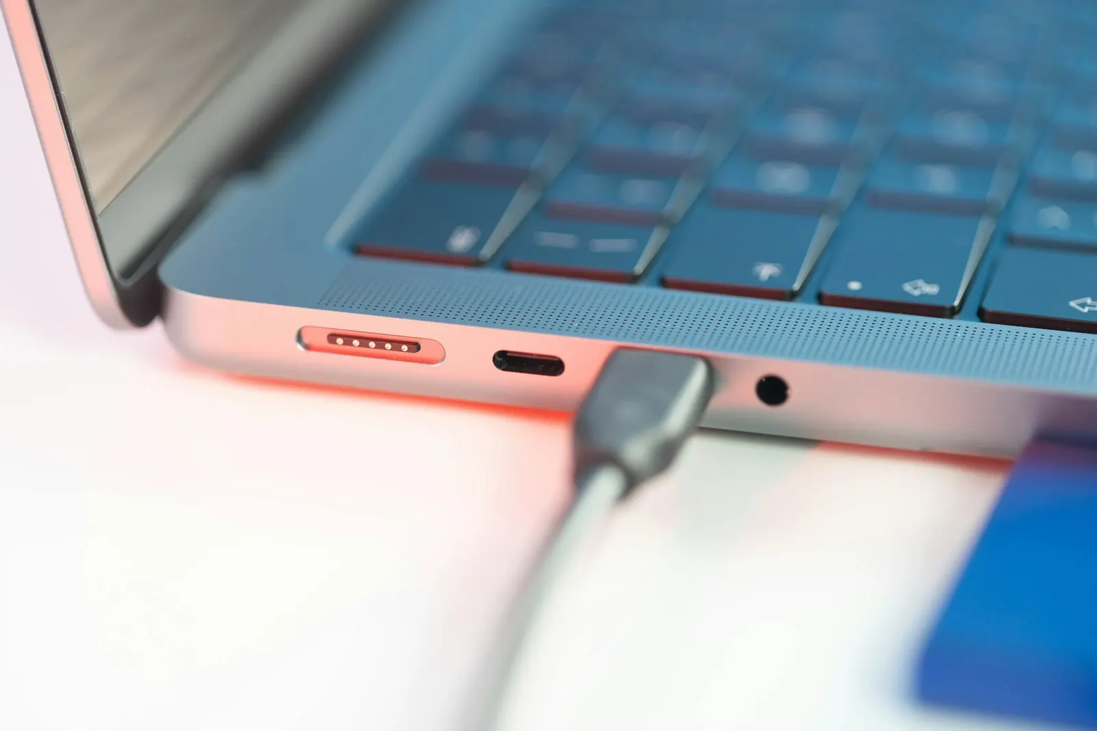 A MacBook Pro with a USB-C cable plugged in beside its MagSafe port