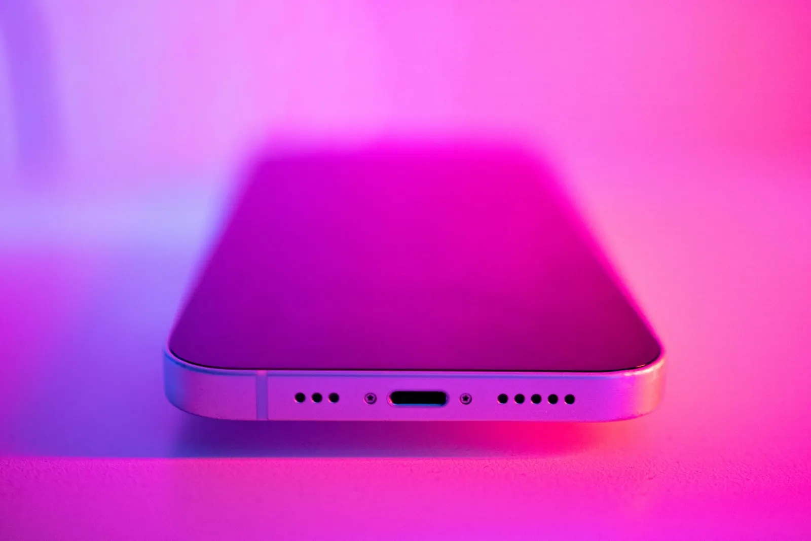 Close up of the charging port and speaker grilles on the bottom edge of an iPhone
