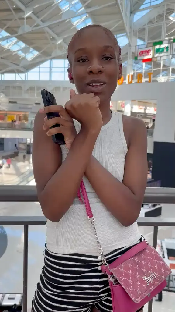 A CELLTECH customer holding her repaired phone by the food court at The Parks Mall