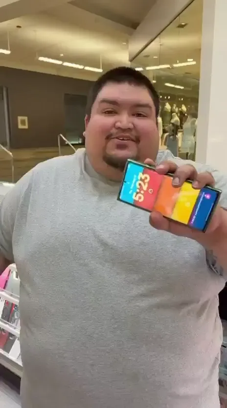 A CELLTECH customer holding up his repaired phone at the North East Mall kiosk