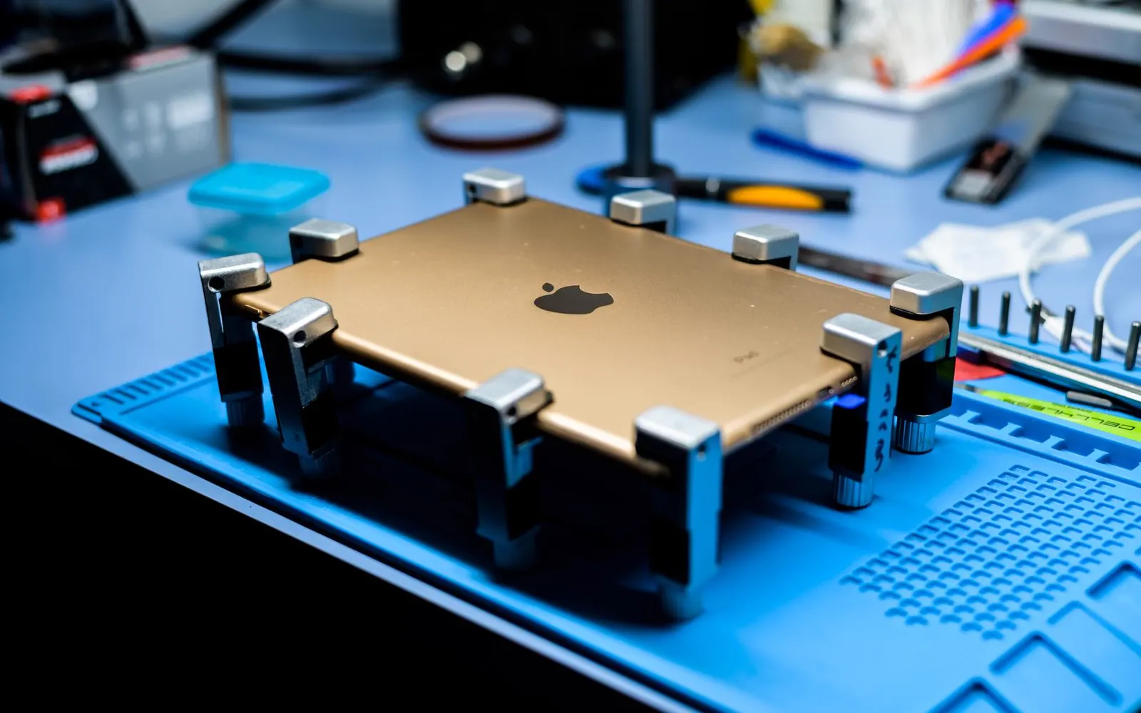 A device being worked on at a repair bench with tools laid out around it