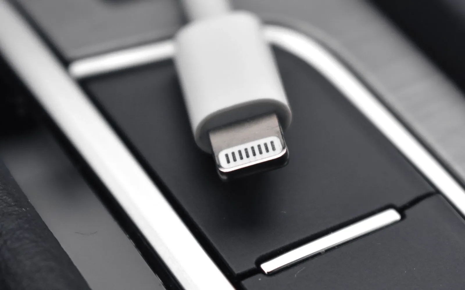 A close-up of a Lightning connector against a black surface