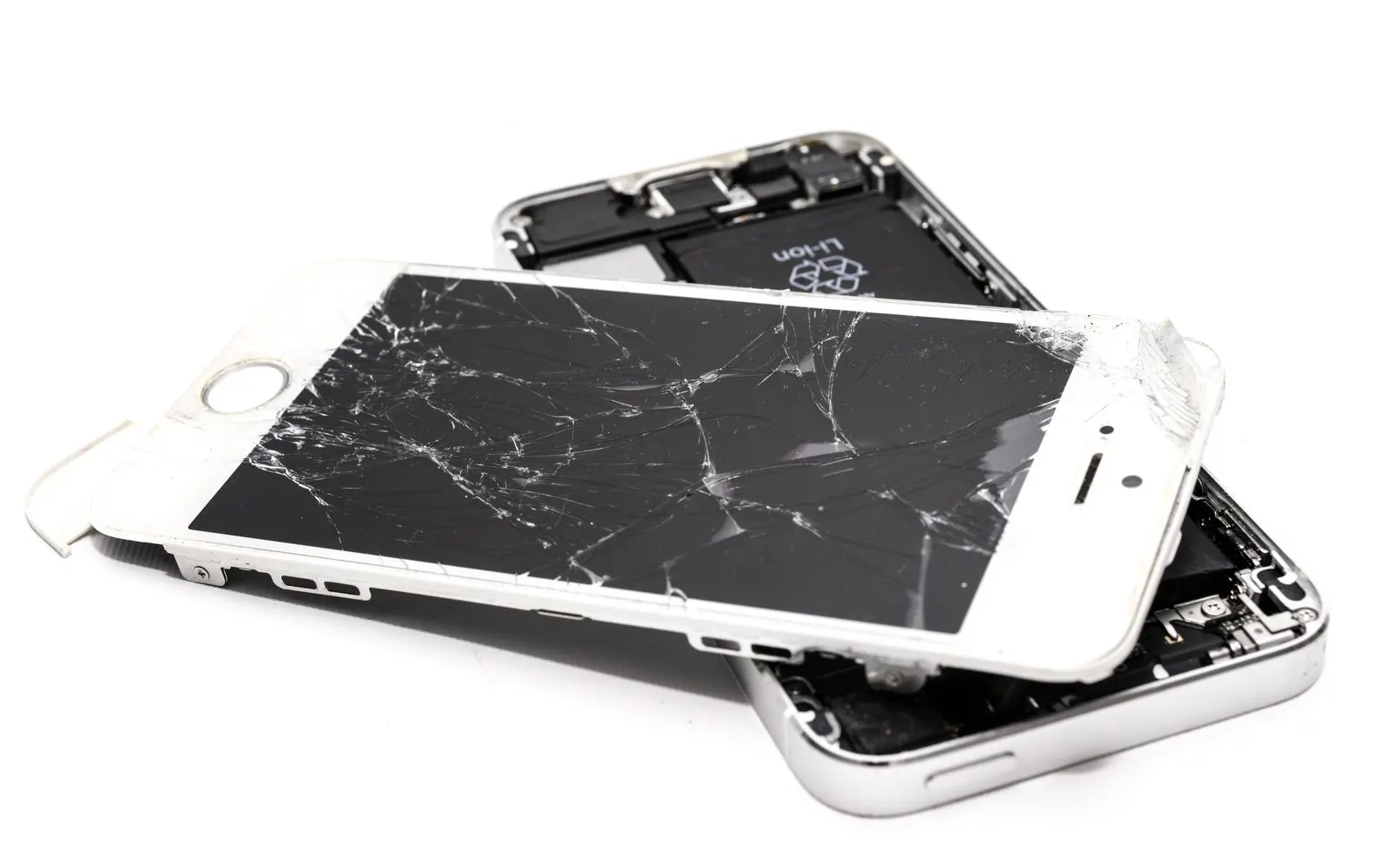 A shattered iPhone display assembly lifted off its frame, the battery and internals visible underneath
