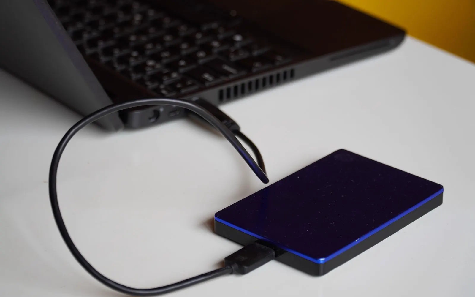 An external drive connected to a laptop on a desk