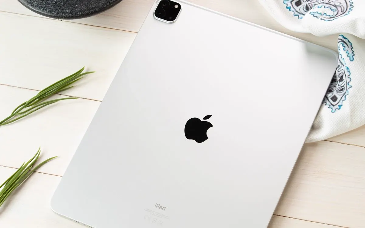 A grey iPad Pro lying flat on a plain surface