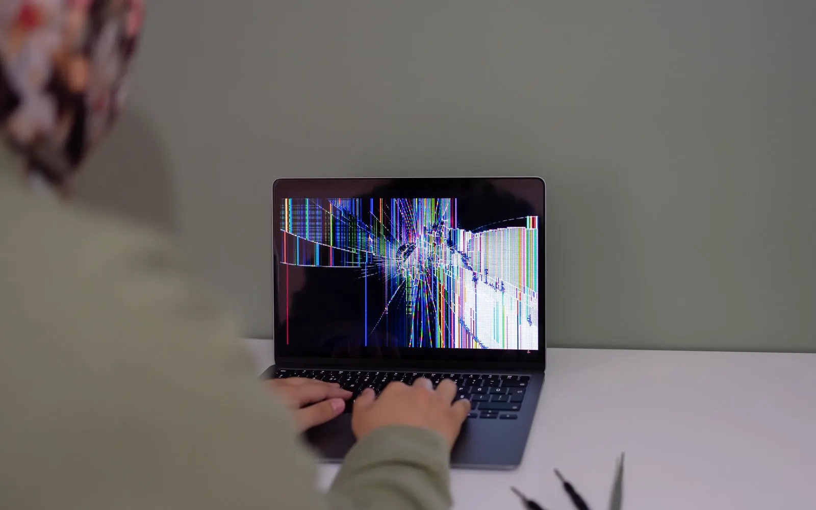 Someone working on a laptop with a damaged screen