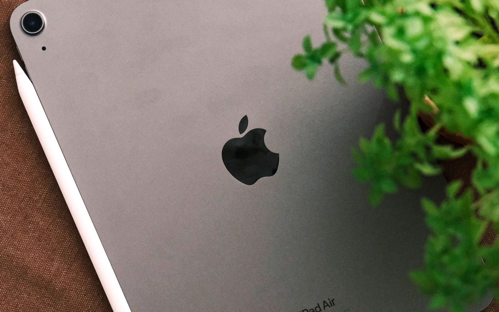 A tablet and stylus seen from above on a brown surface