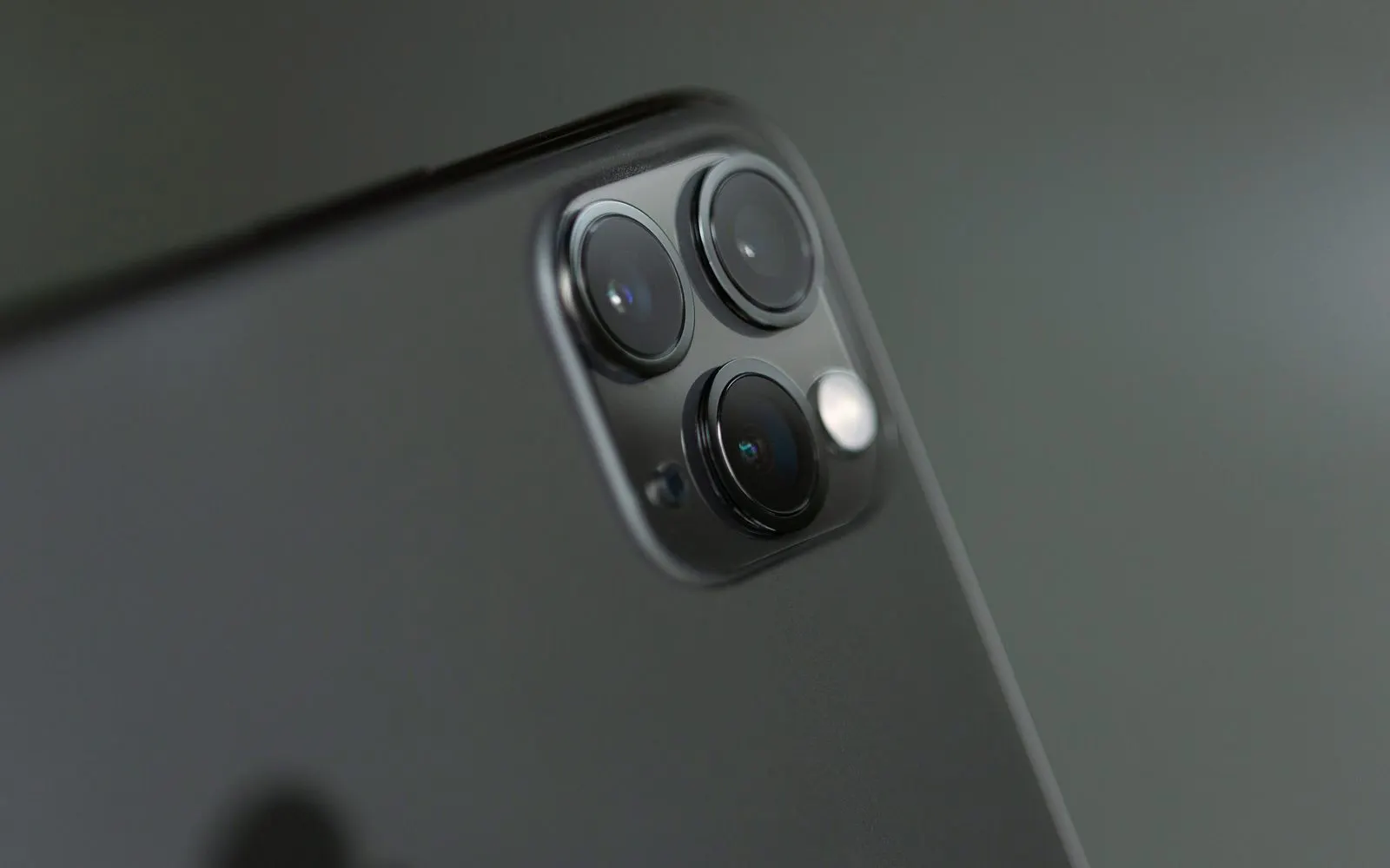 Close-up of the triple rear camera on a dark iPhone Pro