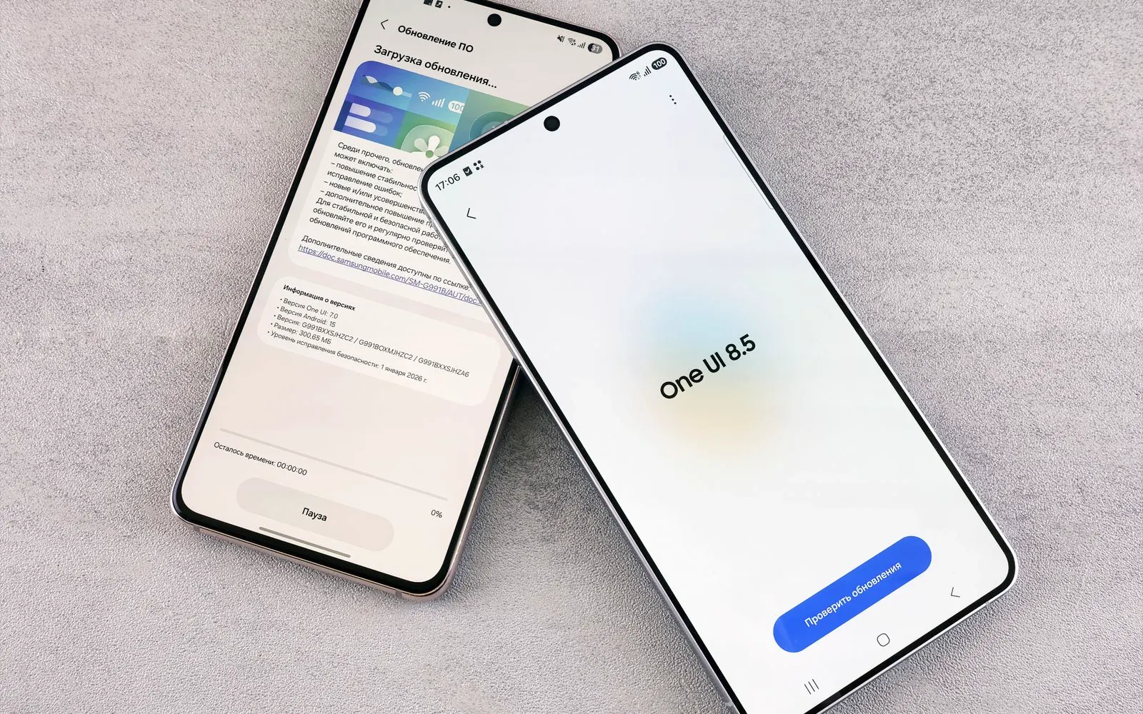 Two Galaxy phones on a desk showing a One UI software update screen