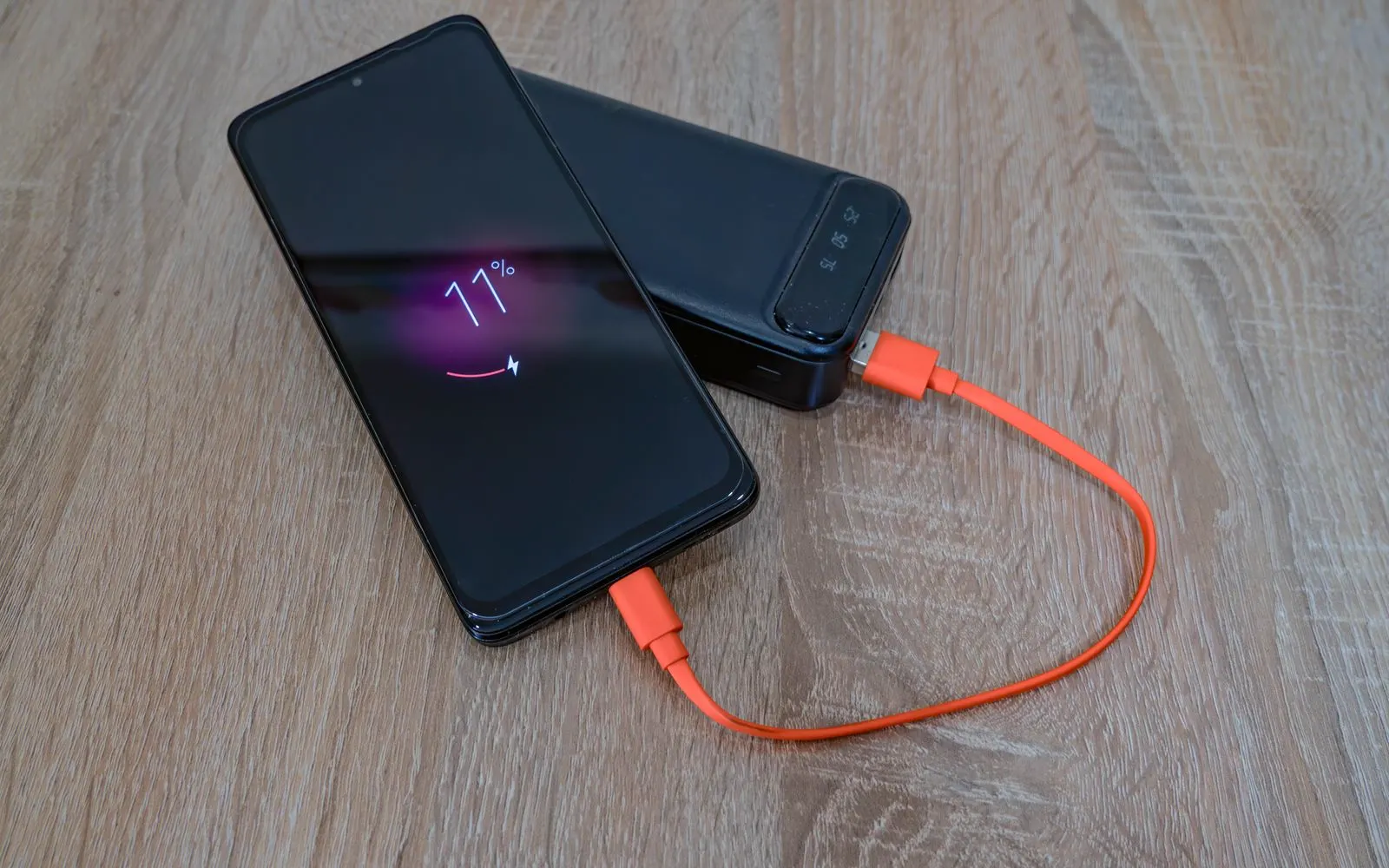 A smartphone charging from a portable power bank