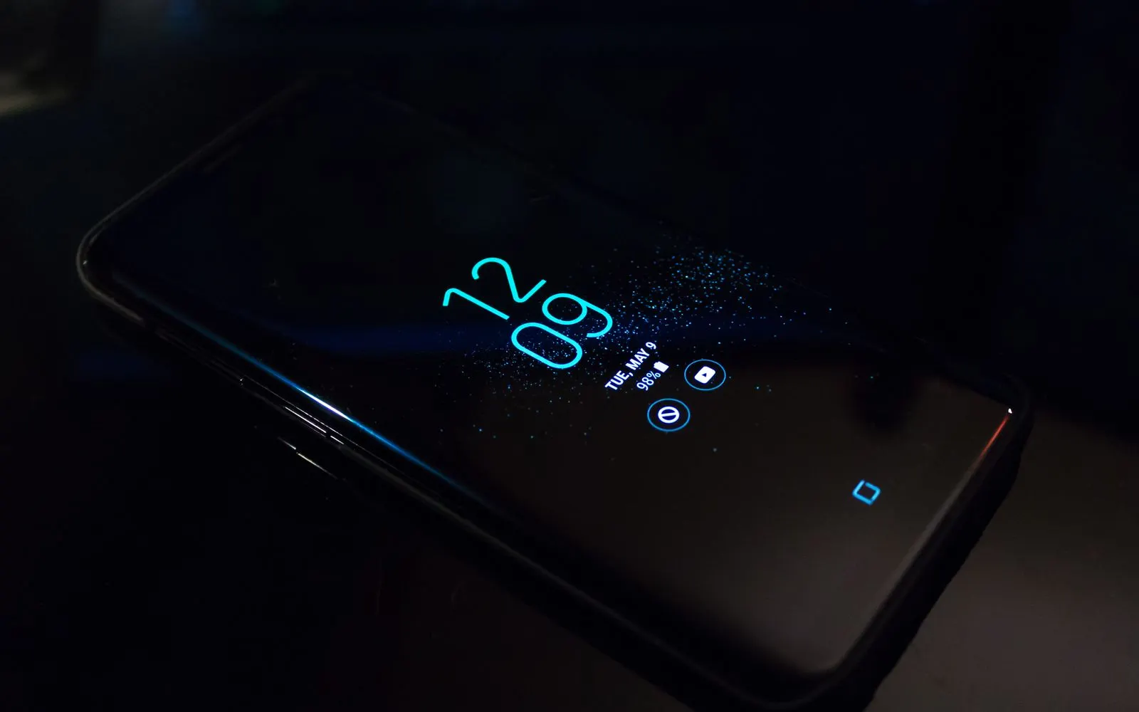 A Samsung Galaxy lying in the dark with only its always on display clock lit