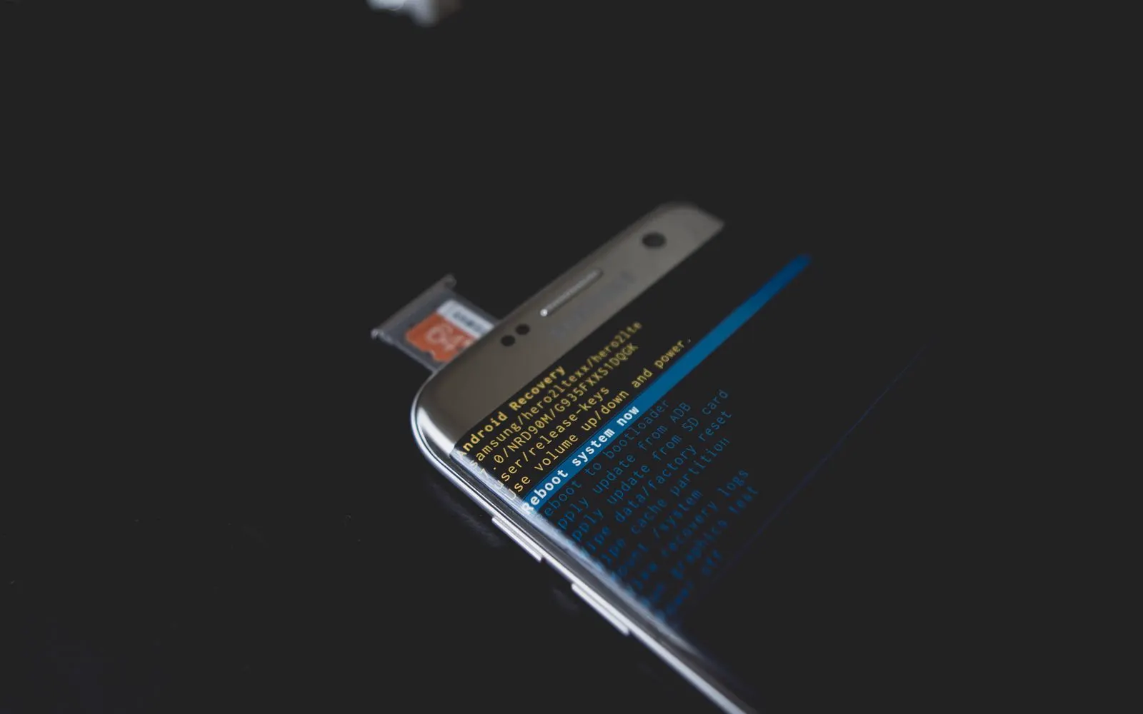 An Android phone showing recovery mode with a memory card beside it