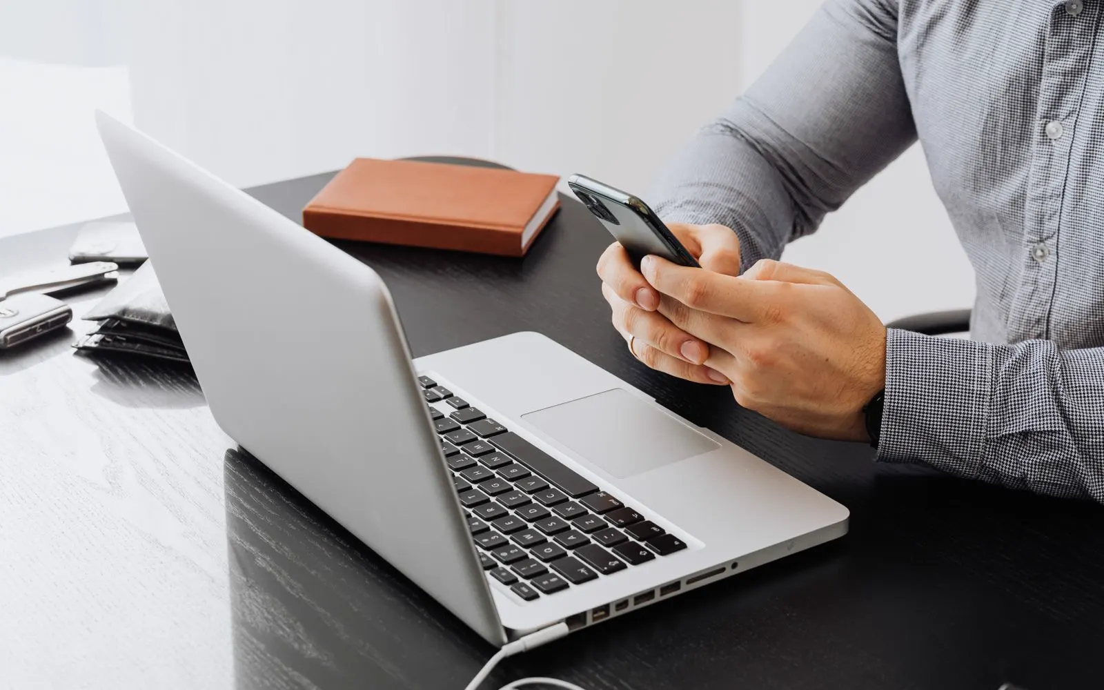 A phone and a laptop side by side on a desk