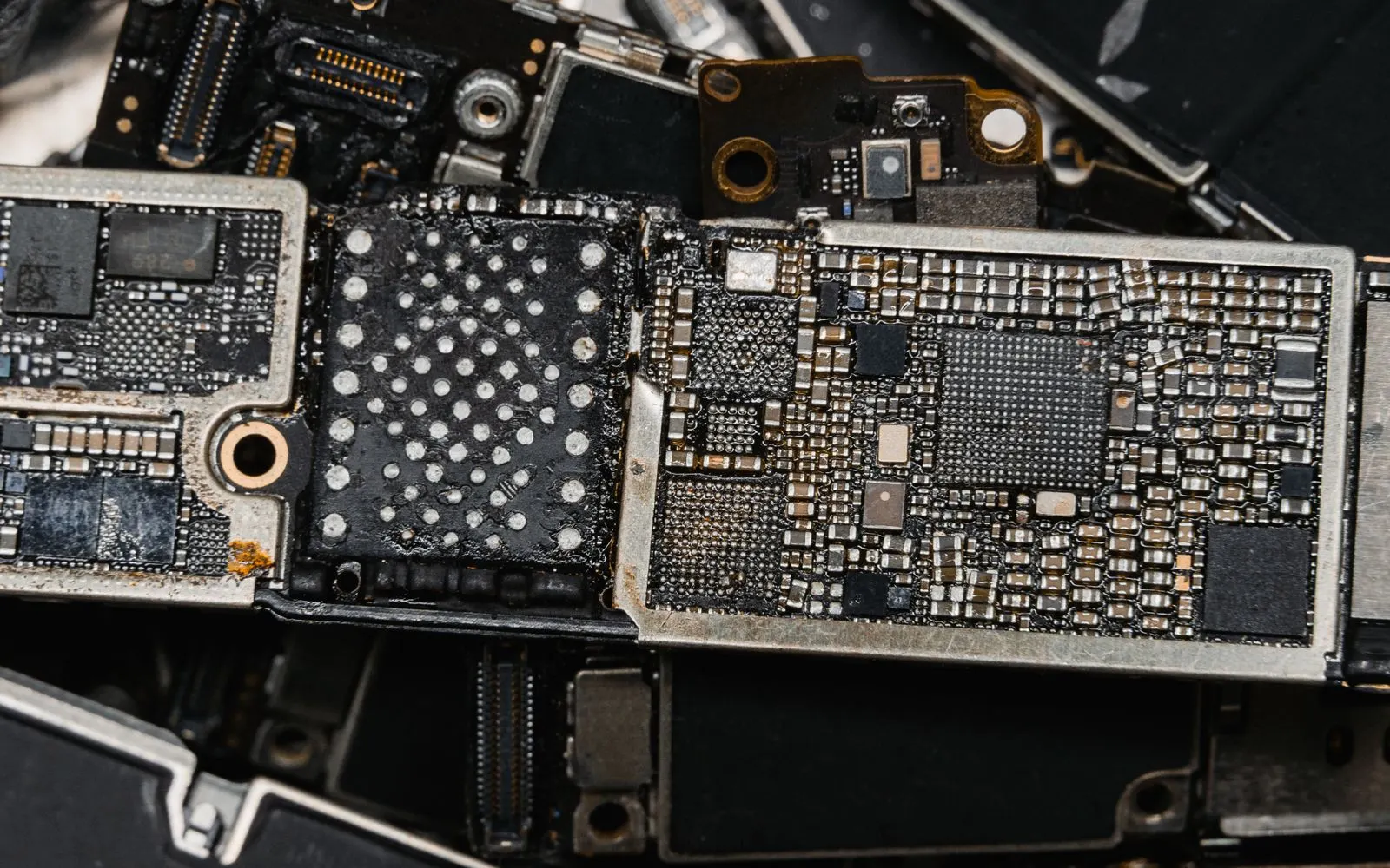Several iPhone logic boards laid out on a repair bench