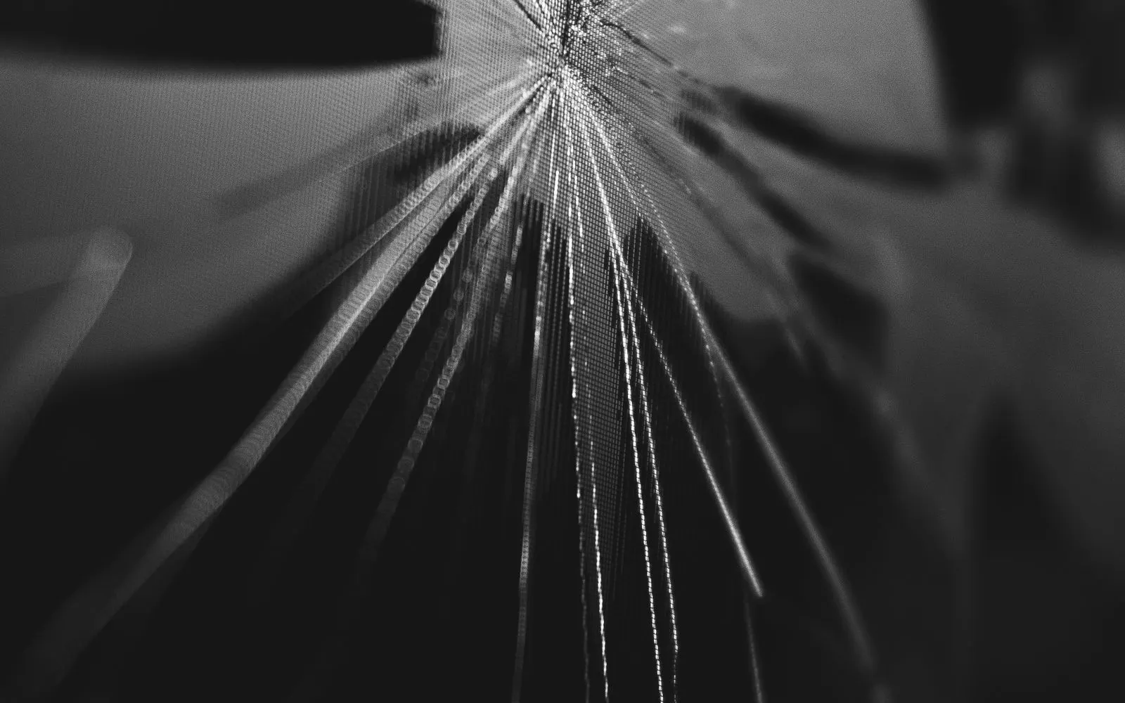 Cracks radiating across a phone display, the pixel grid visible beneath the broken glass