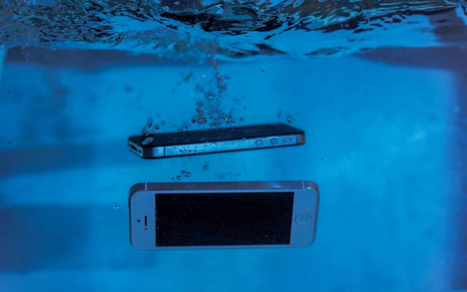Two smartphones submerged in clear water during a resistance test