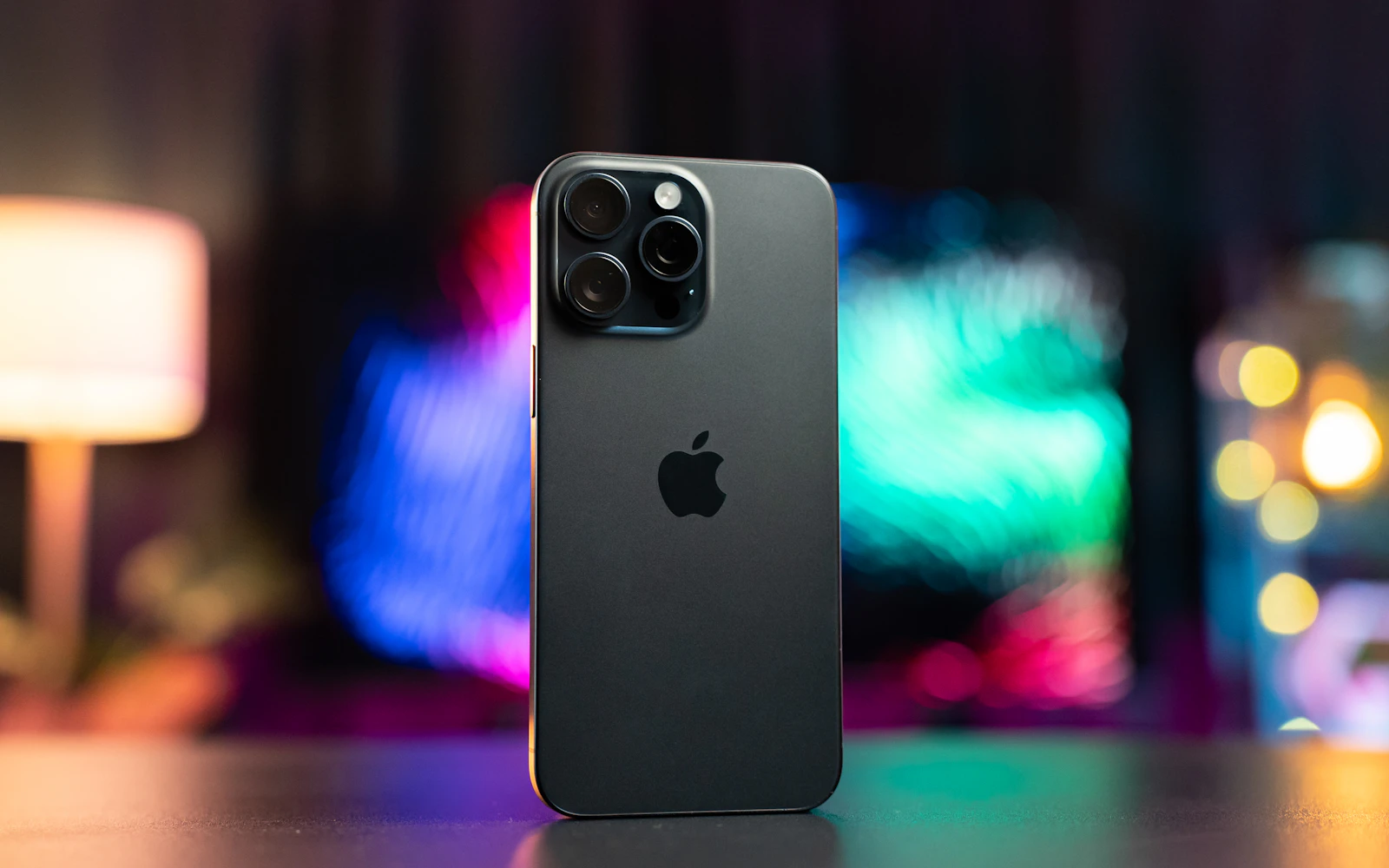 A recent iPhone Pro standing on a table, its triple rear cameras in clear view