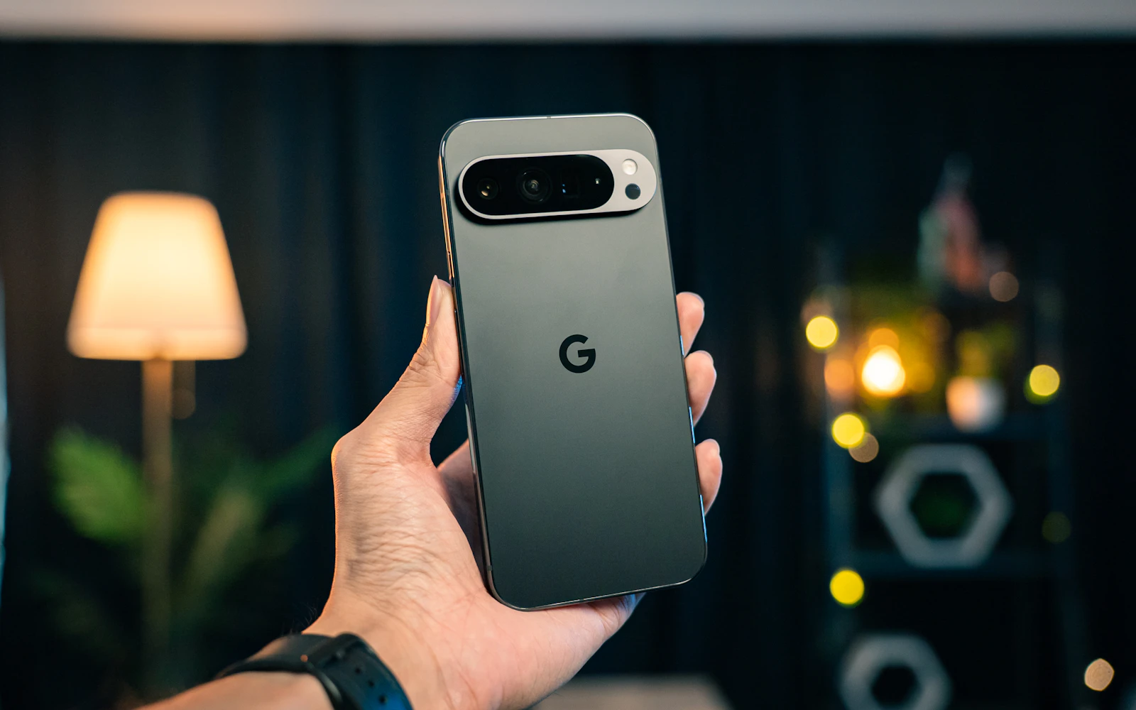 A hand holding a Google Pixel phone, its wide camera bar facing the lens