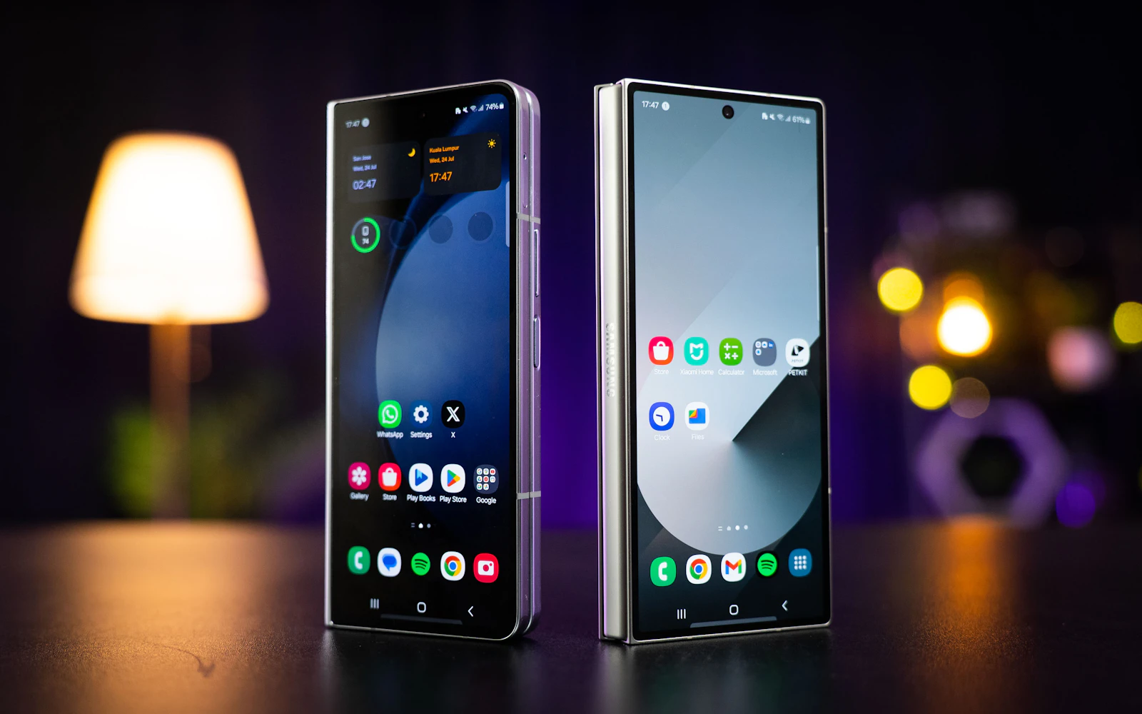 A Samsung Galaxy Z Fold and Z Flip standing open side by side on a table, both screens lit