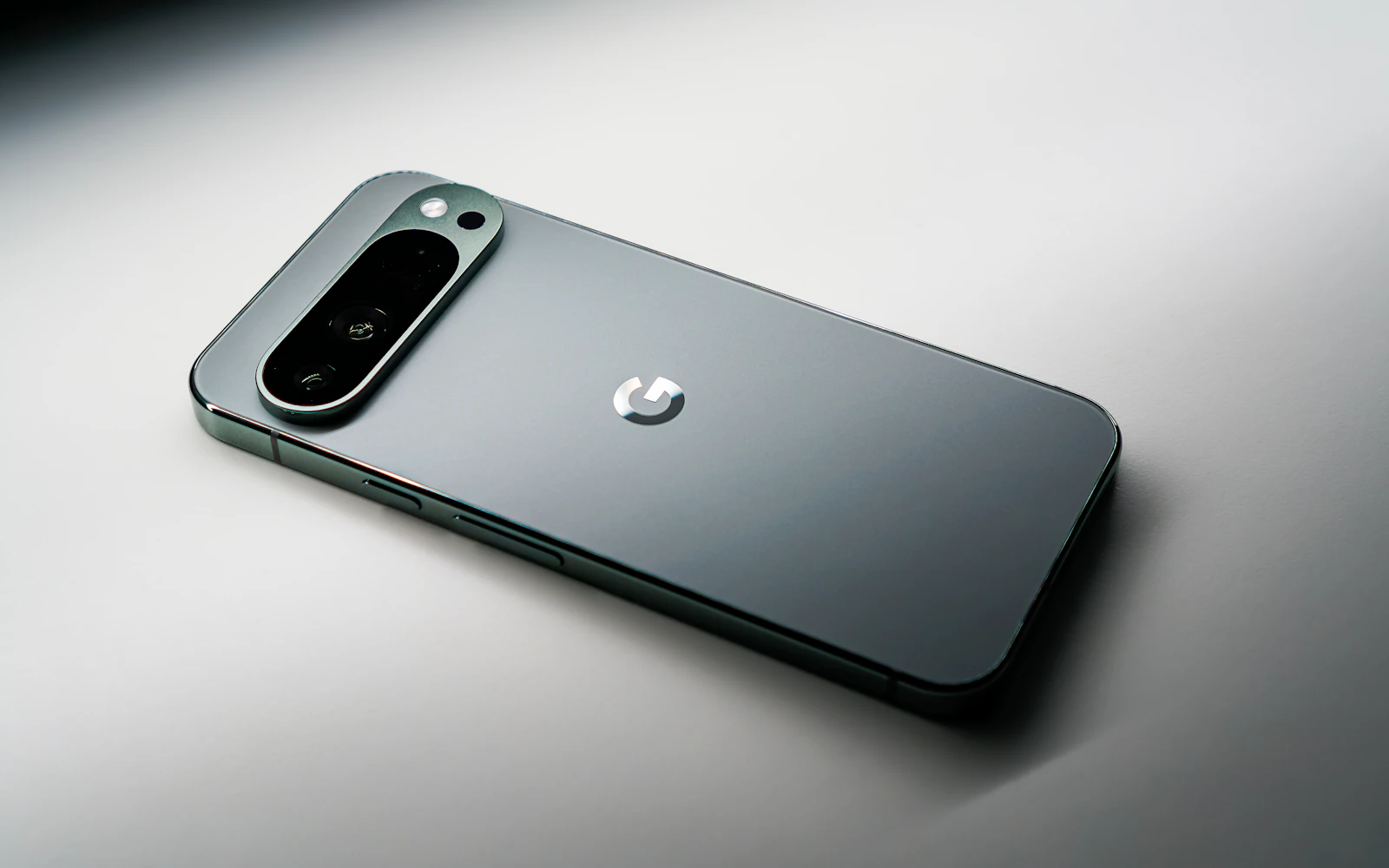 A Google Pixel lying face down on a white surface, its camera bar catching the light