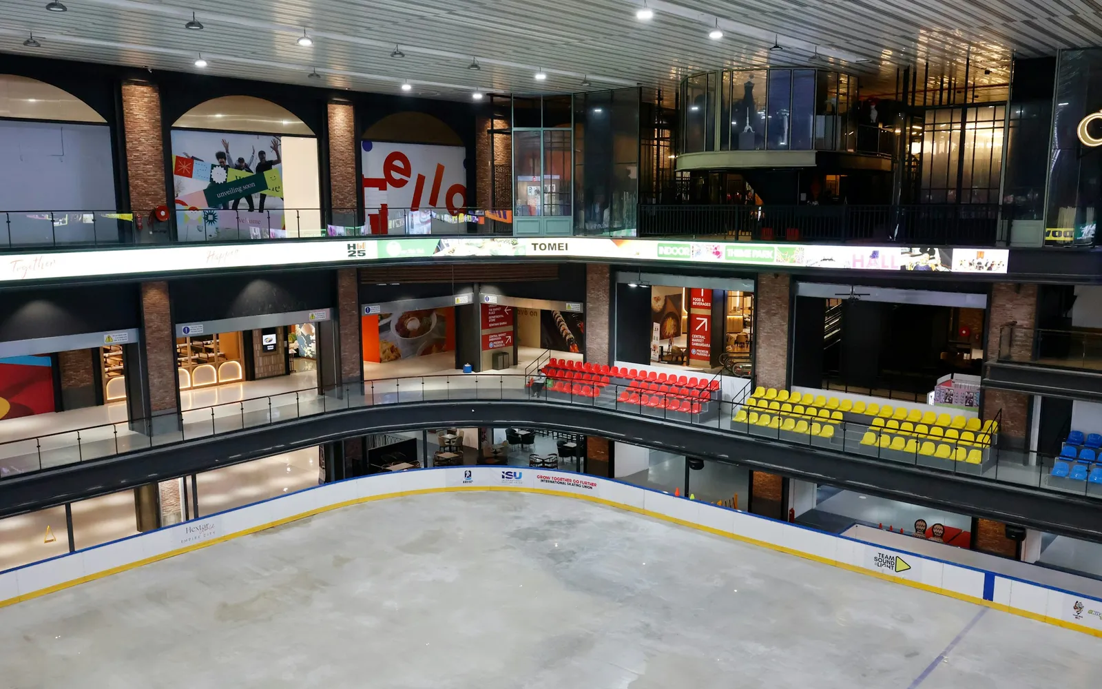 Shop fronts on two levels of a shopping mall looking down onto an indoor ice rink